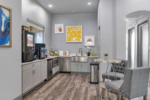 A modern kitchen with a grey chair and a table.