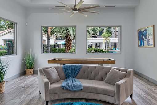 A living room with a couch and a ceiling fan.