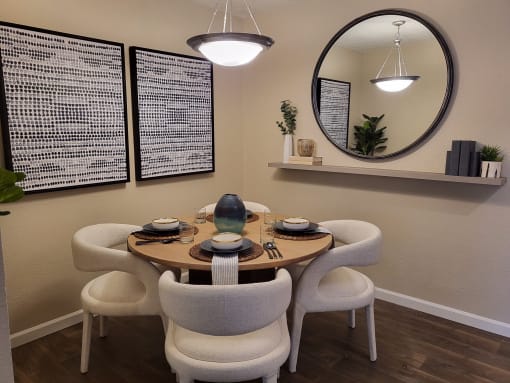a dining room with a round table and white chairs