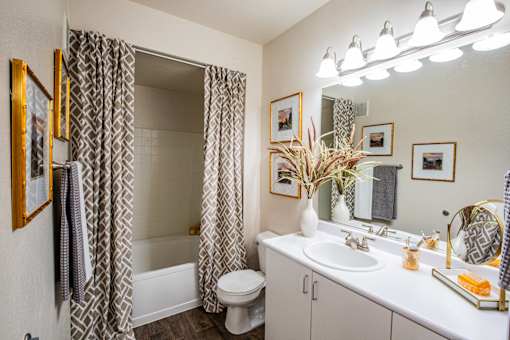 A bathroom with a white sink, toilet, and a mirror.