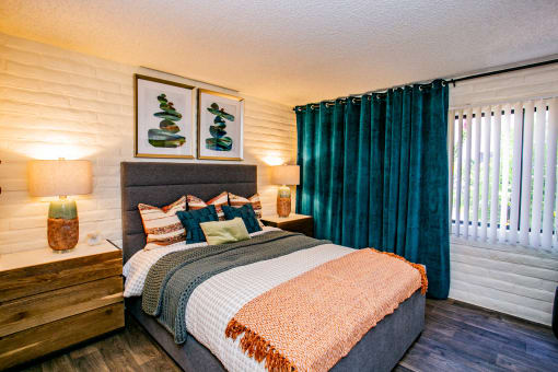 a bedroom with a bed and a window with green curtains