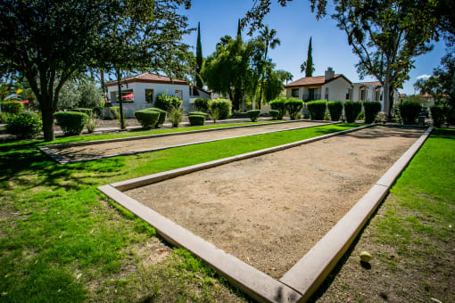 a yard with a path and houses in the background