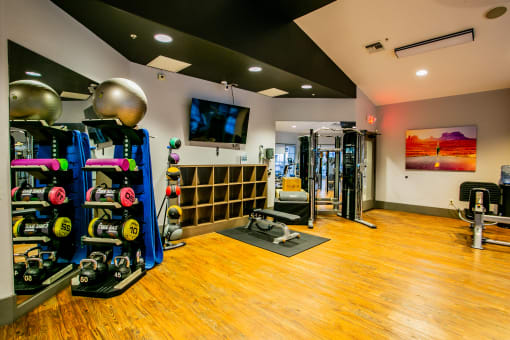 a home gym with weights and a tv on the wall