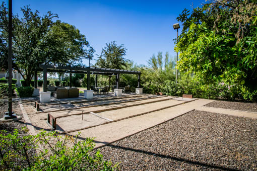 a patio with benches and a pavilion in a garden