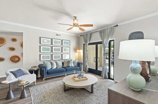 A living room with a blue couch and a white chair.