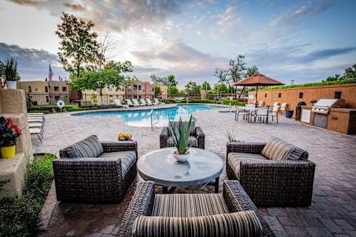 Lounge Area on Pool Deck with Cushion Chairs at Rancho Carrera Apartments NM