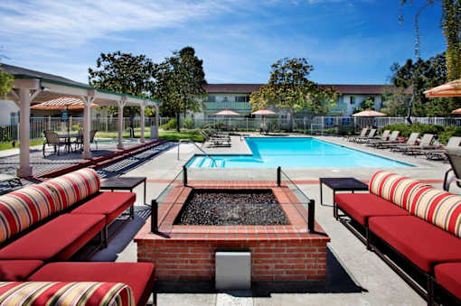 a pool with red and white lounge chairs and a swimming pool