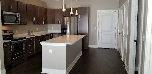 A kitchen with dark brown cabinets and a white island.