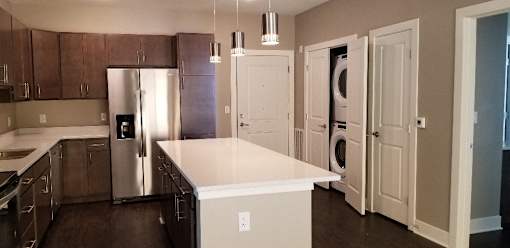 A kitchen with a white island and a refrigerator.
