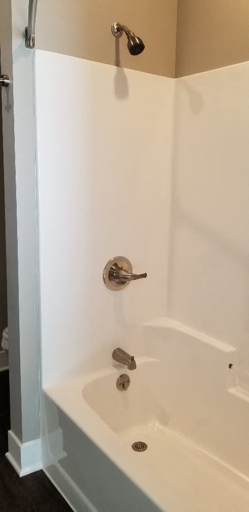 A white bathroom with a tub and a shower.