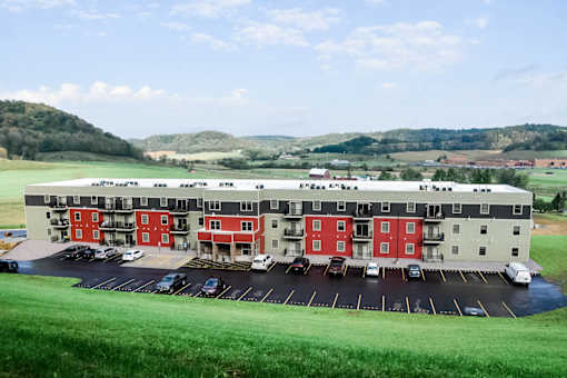 A large red and white building with a parking lot in front.
