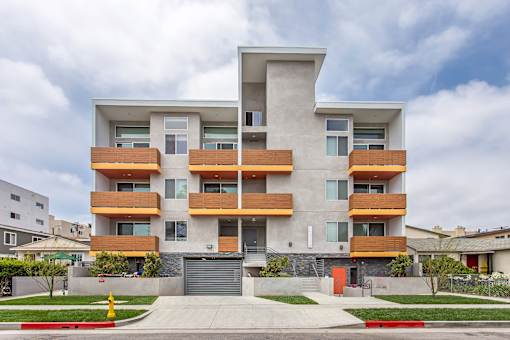 A modern apartment building with a mix of wood and concrete exterior.