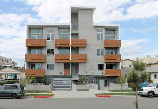 A modern apartment building with a mix of white and brown balconies.