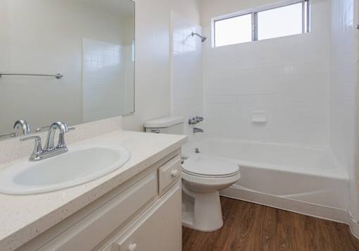 A white bathroom with a toilet, sink, and bathtub.