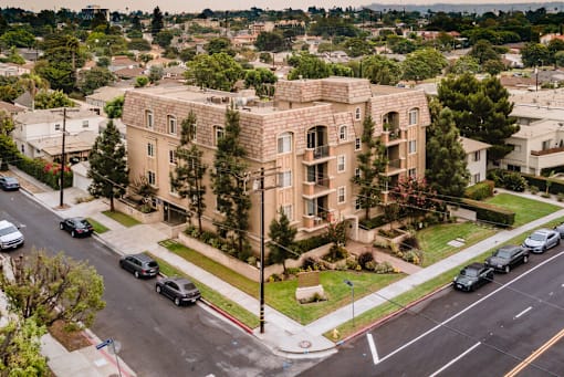 A large building with a green lawn in front of it at Lido Apartments - 2810 S Sepulveda, Los Angeles CA 90064