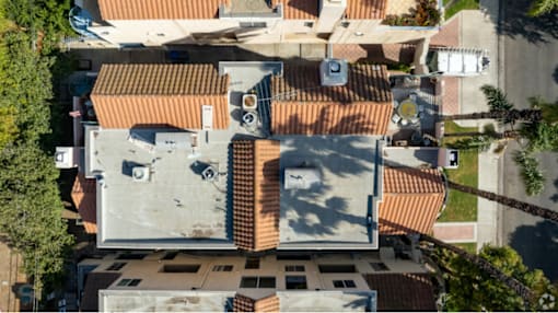 A top-down view of a residential area with terracotta roofs.