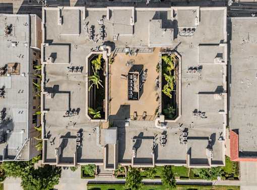 A courtyard surrounded by buildings with a fountain in the middle.