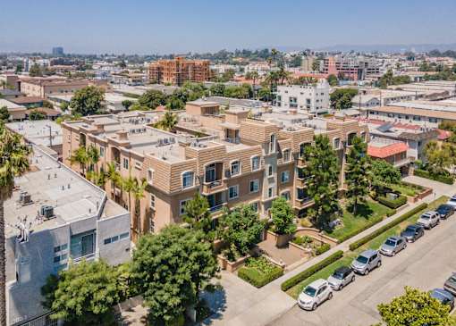 A residential area with apartment buildings and parked cars.