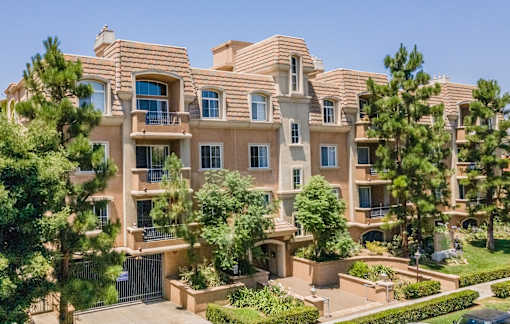 A large, multi-story residential building with a balcony on the second floor.