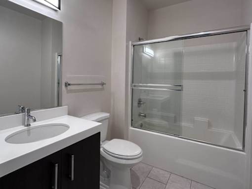 Modern bathroom with glass sliding shower doors at Lido - 3630 Mentone Ave Apartments, California, 90034