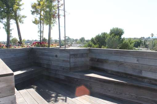 A wooden deck with steps and a bench.