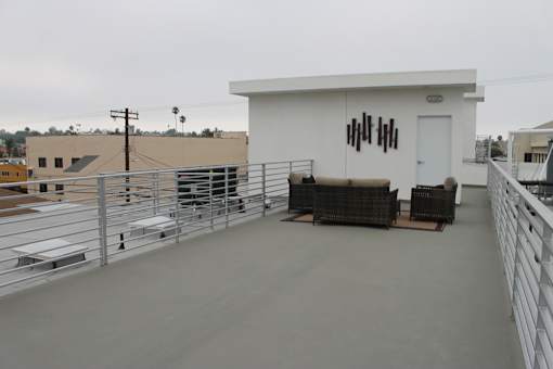 Rooftop terrace with outdoor furniture and city views at Lido - 3630 Mentone Ave Apartments, Los Angeles, CA 90034