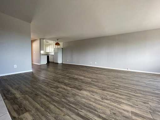 A room with wooden flooring and white walls at Lido Apartments, Los Angeles