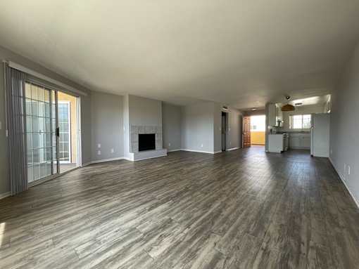 A spacious room with wood flooring and a fireplace at Lido Apartments, Los Angeles, CA 90066