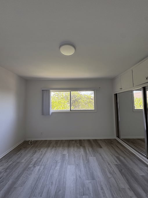 A room with a window and a grey floor.