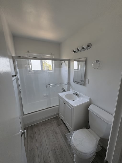 A bathroom with a toilet, sink, and shower.