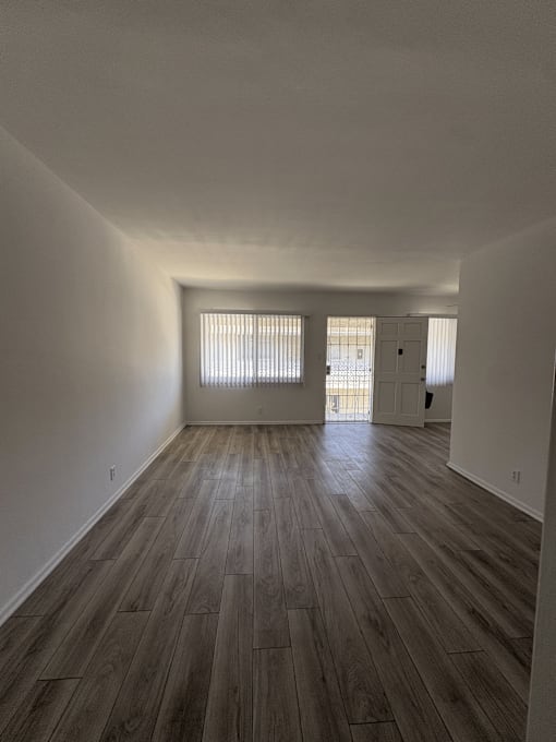 A room with wooden flooring and white walls.