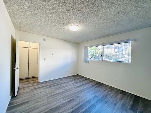 A room with a grey floor and a window letting in light.