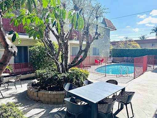 A backyard with a table and chairs and a pool.