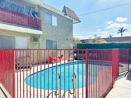 A red fence surrounds a small pool.