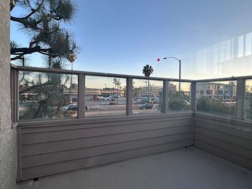 A balcony with a view of a street and buildings.at Lido Apartments - 101-197 N Ridgeway, Anaheim, 92801