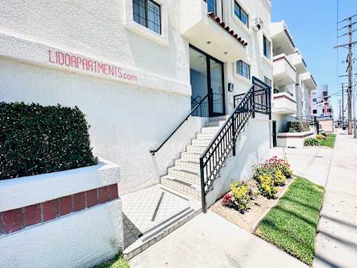 A white building with the name LIDOAPARTMENTS.COM on the side.
