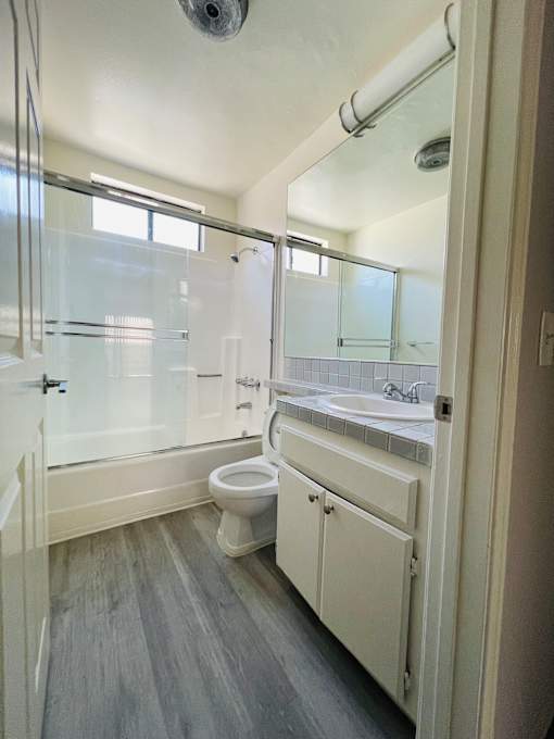 A bathroom with a toilet, sink, and shower.