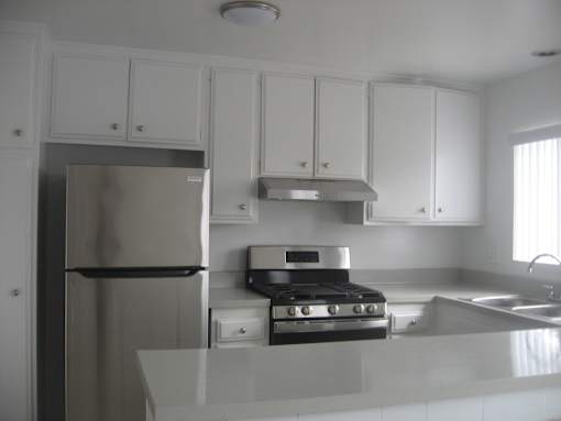 A kitchen with white cabinets and stainless steel appliances.