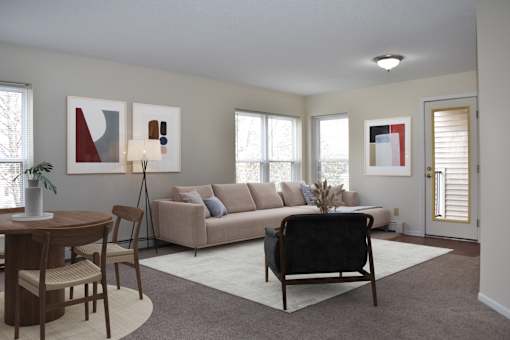 A living room with a couch, a chair, a table, and a potted plant.