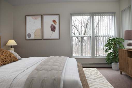 A bedroom with a large bed and two framed artworks on the wall.