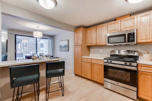 A kitchen with wooden cabinets and a stainless steel oven.