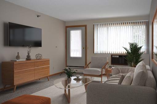 A living room with a grey couch, a wooden cabinet, a television, and a window with blinds.