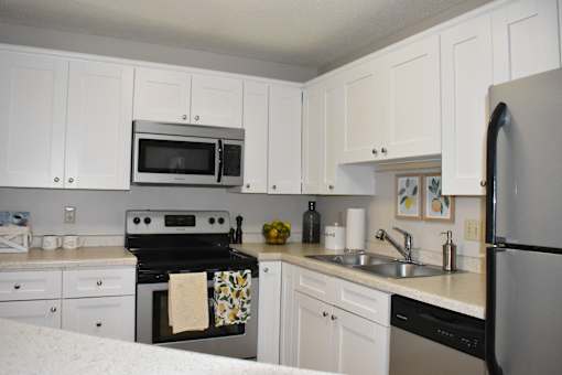 A kitchen with white cabinets and appliances.