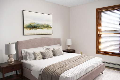 A bedroom with a large bed and a painting on the wall.
