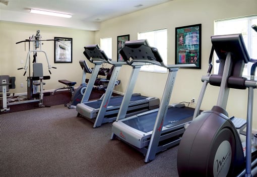 a room with three treadmills and other exercise equipment