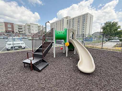 A playground with a slide, stairs, and a platform.