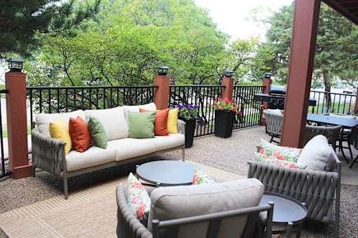 A patio with a couch, chairs, and a table.