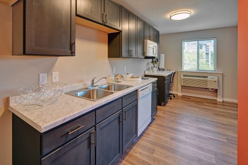 a kitchen with wood flooring and a large counter with a sink