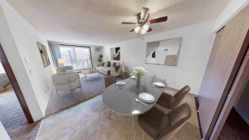 a living room with a dining table and a ceiling fan