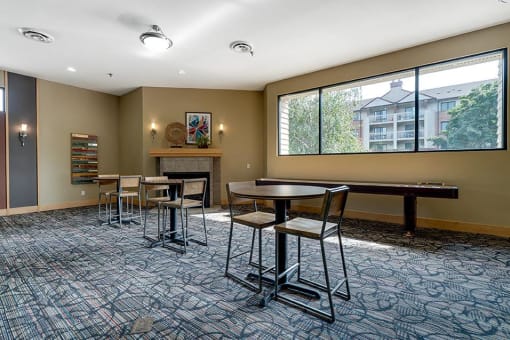 Community room with small tables and chairs and a window